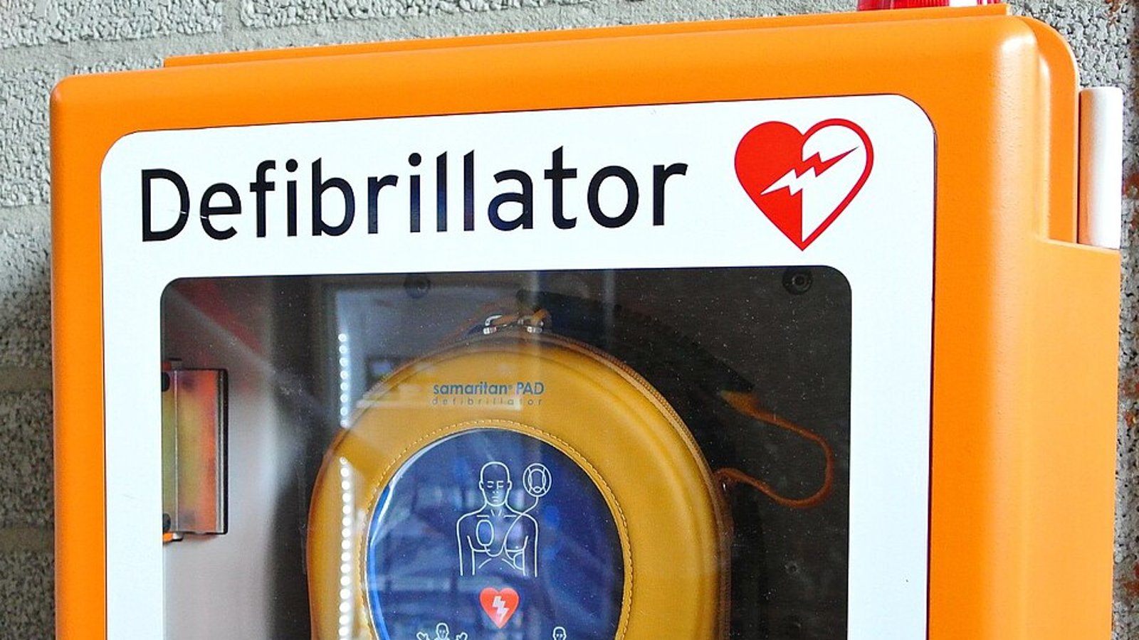 Défibrillateur automatisé externe dans un boîtier mural orange
