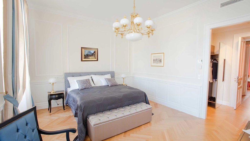 Chambre à coucher avec lit, banc capitonné et penderie ouverte