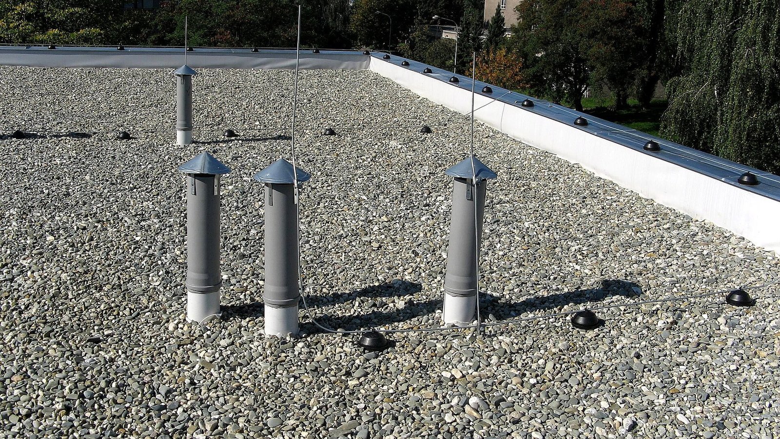 Toit plat couvert de gravier avec plusieurs conduits de ventilation visibles